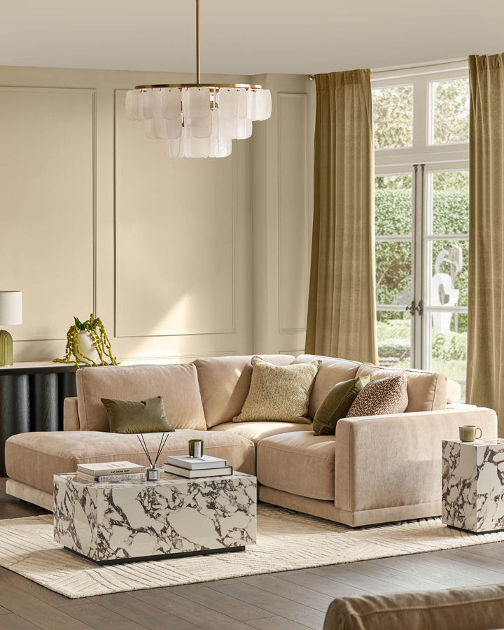 Eden Left Small Chaise Sofa in champagne fabric, displayed in a bright living room with coordinating pillows and marble side table.