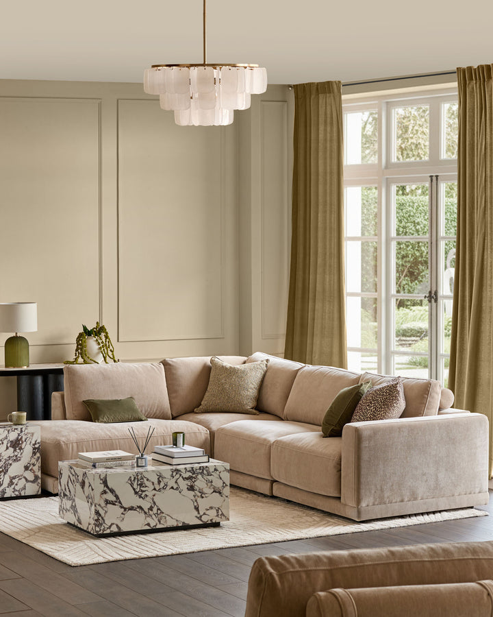Champagne upholstered sectional sofa with left-facing chaise, shown in styled living room setting with neutral décor.