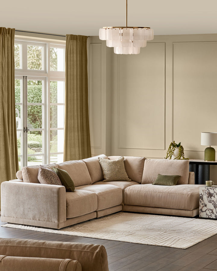 Eden right-facing large chaise sectional sofa in champagne fabric in a light-filled living room setting.