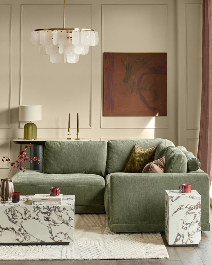 Dark green upholstered left-facing small chaise sectional sofa in a modern living room setting.