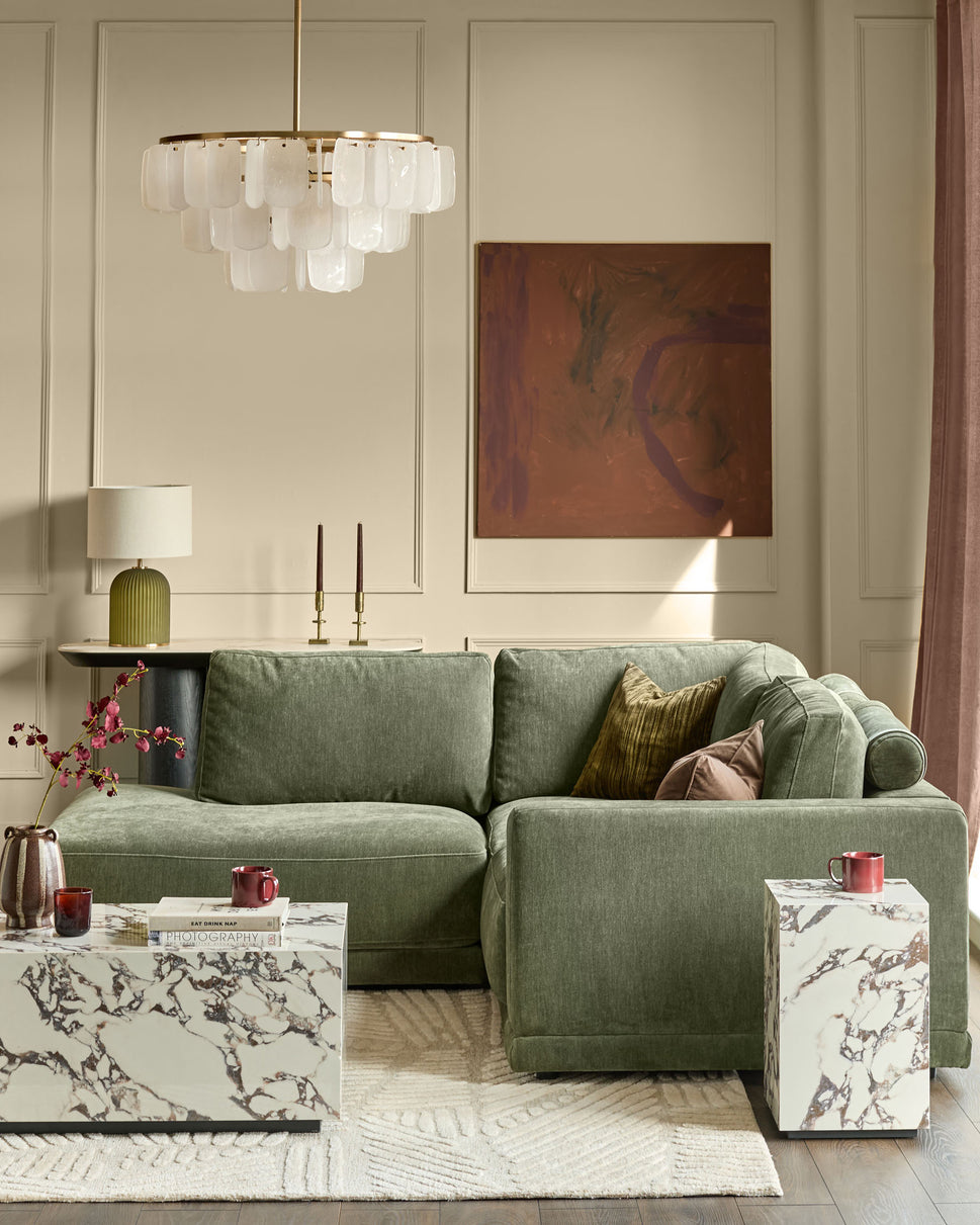 Dark green upholstered left-facing small chaise sectional sofa in a modern living room setting.