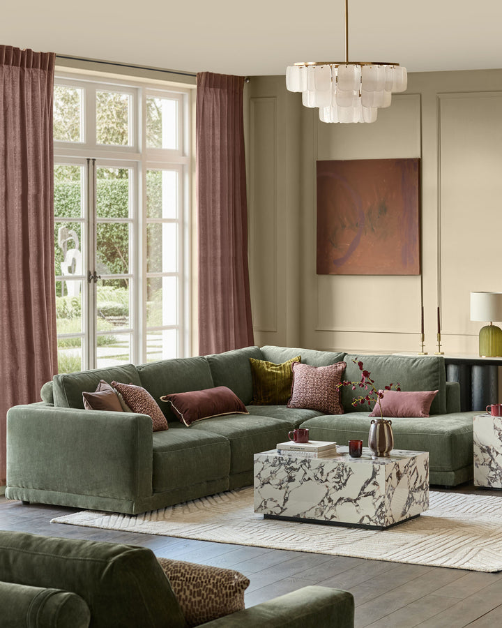 Dark green right-facing sectional sofa with chaise lounge, displayed in a modern living room setting with decorative pillows.