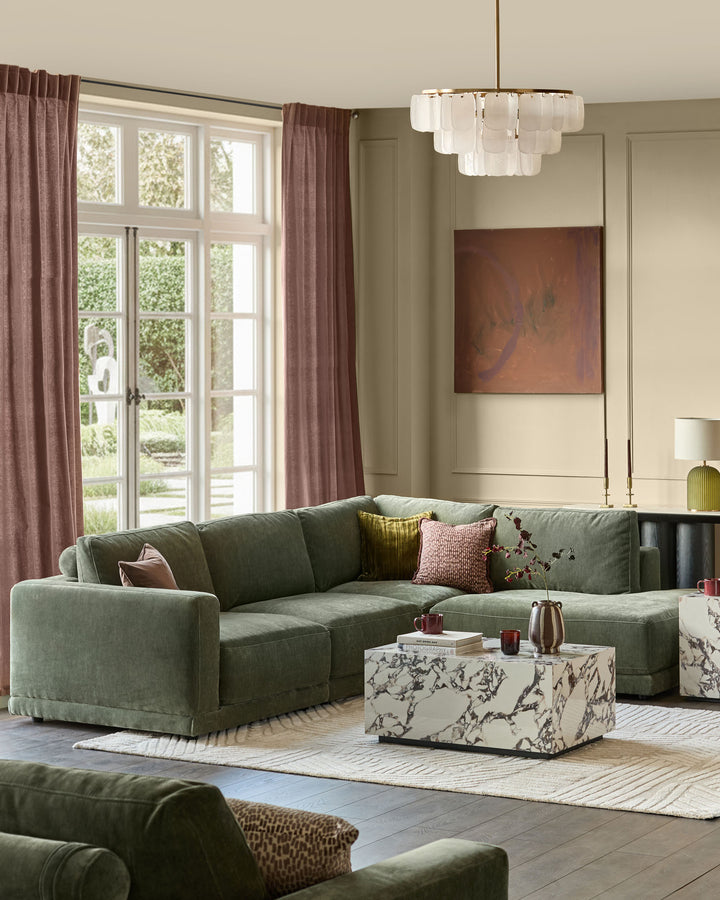 Dark green fabric right-facing sectional sofa with chaise lounge in modern living room setting.