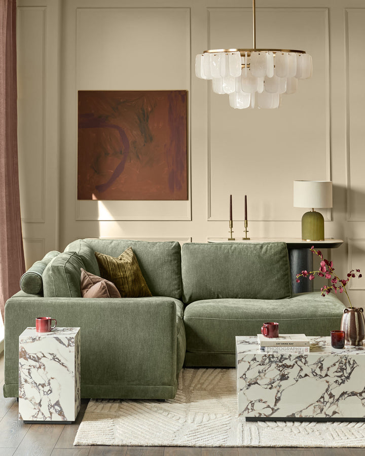 Dark green fabric right-facing small chaise sofa with rolled arms and cushioned back in modern living room setting.