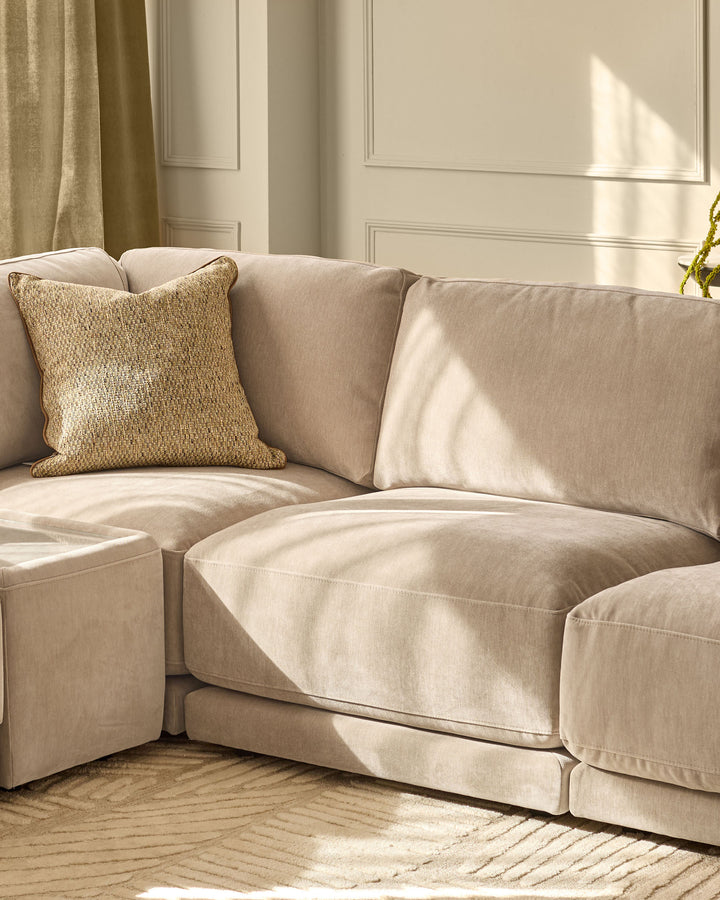 Eden 2-seater sofa in champagne fabric with textured cushion, positioned in bright room with natural light and neutral decor.