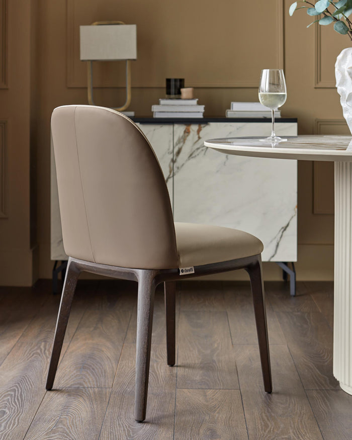 Dining room with marble-effect sideboard, round table and modern upholstered dining chair.