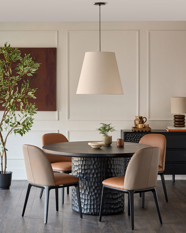 Tan leather Emerson dining chair with mocha accents, shown in a modern dining room setting around a black textured table.