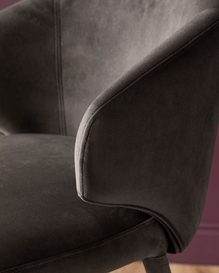 Dark chocolate velvet bar stool with curved backrest and piping detail, side view angle.