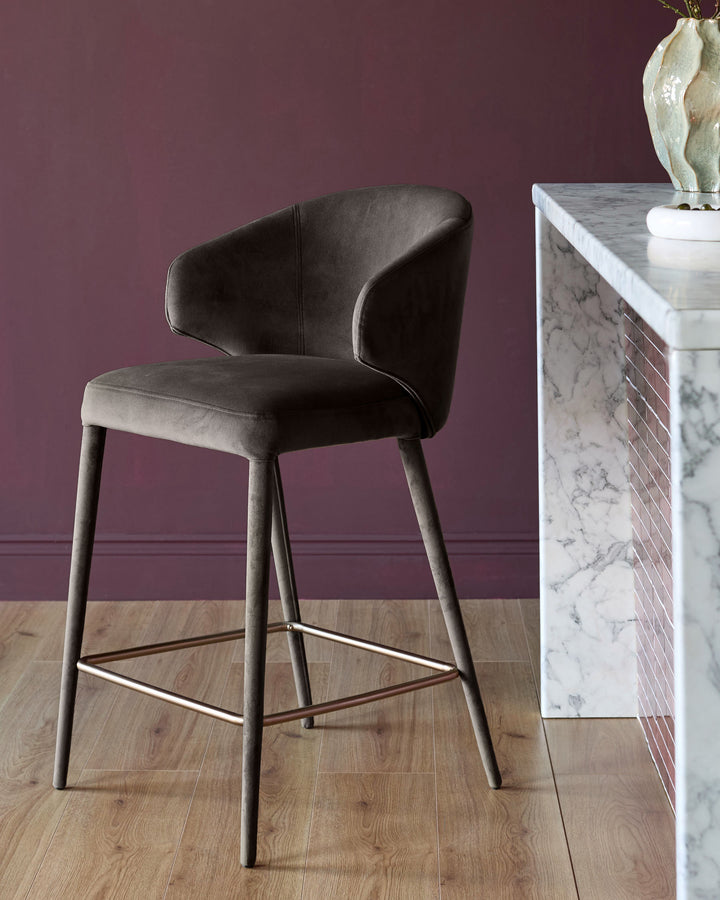 Ethan bar stool in dark chocolate velvet with curved backrest and tapered wooden legs, footrest detail visible.
