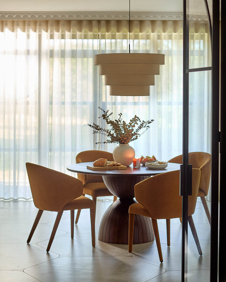 Malin 4-seater dining table in dark mango wood, round top with pedestal base, styled in modern dining room.