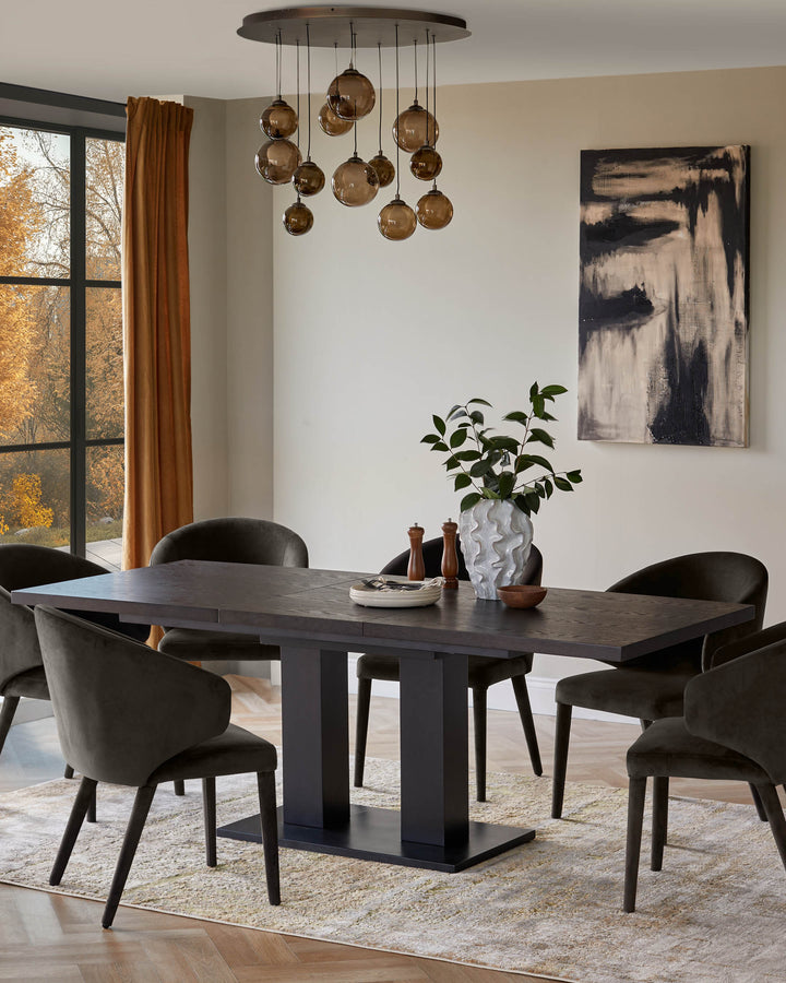 A contemporary dining set with a dark wood table, six upholstered chairs and a statement bubble chandelier above.