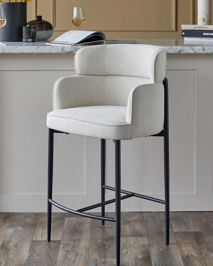 Upholstered bar stool with dark metal legs, perfect for adding a touch of modern sophistication to any kitchen or bar area.