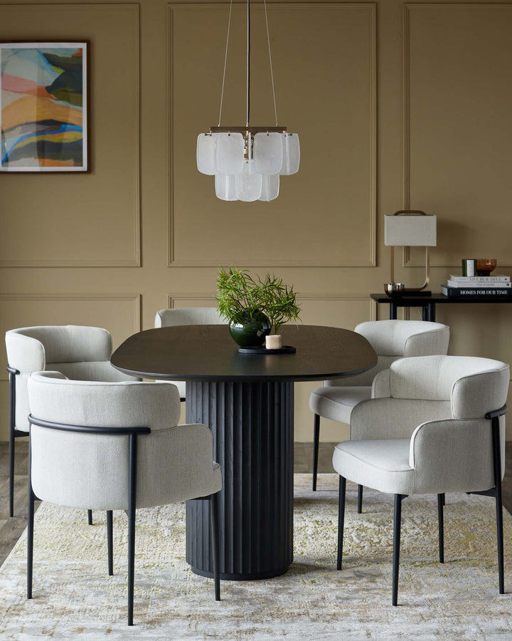 A stylish dining set with a dark wood table, plush chairs, and modern chandelier creates an inviting dining space.