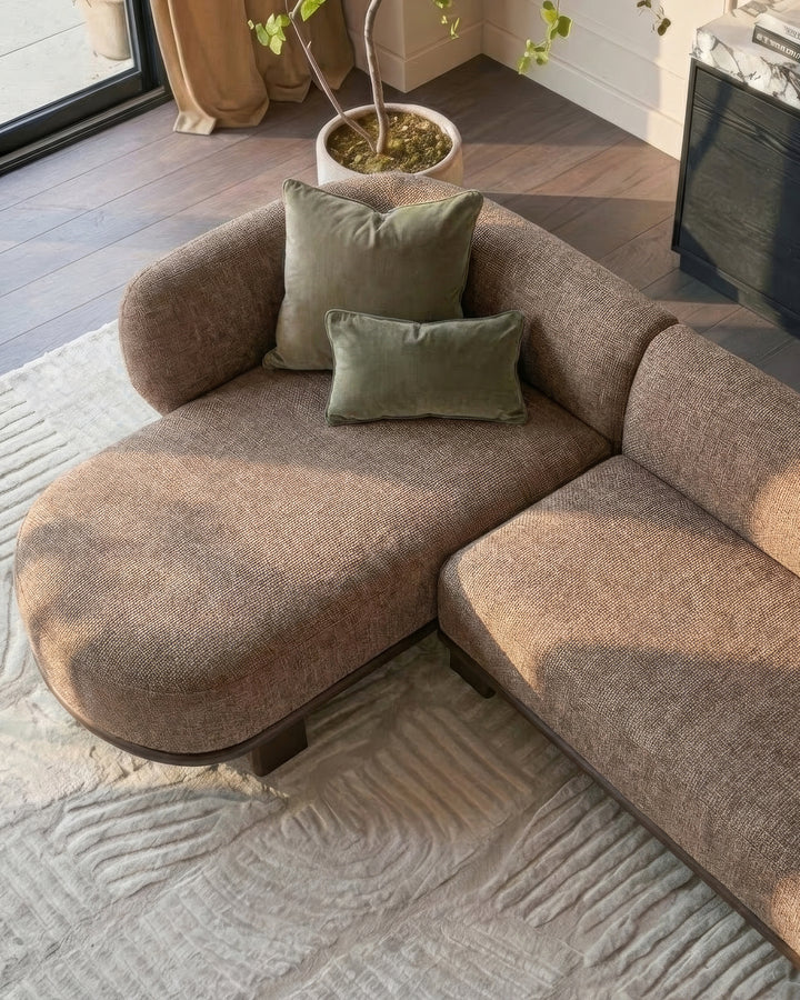 Florence left-hand-facing chaise sofa in mocha fabric with dark wood legs, styled with sage green pillows in a modern living room.