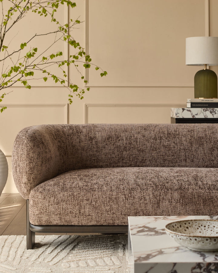 Florence 2-seater sofa in mocha fabric with dark wood base, curved arms, displayed in a styled living room setting.