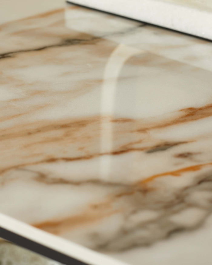 Close-up of a marble tray with a white and black rim, showcasing its unique veining and glossy finish.