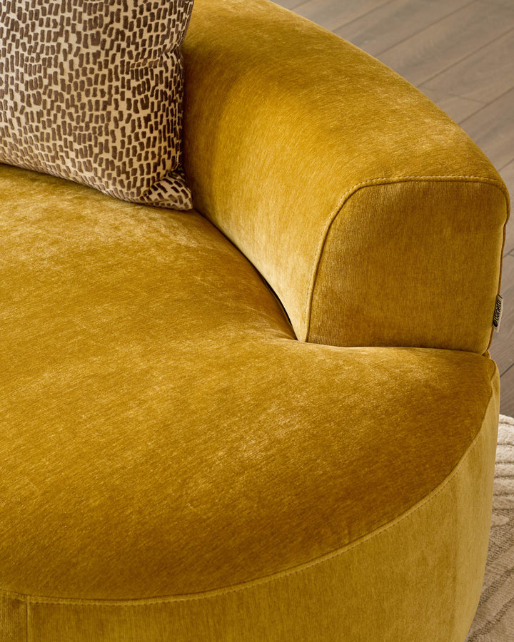 Gianna 2-seater sofa in ochre fabric, close-up of curved armrest and seat with patterned cushion detail.