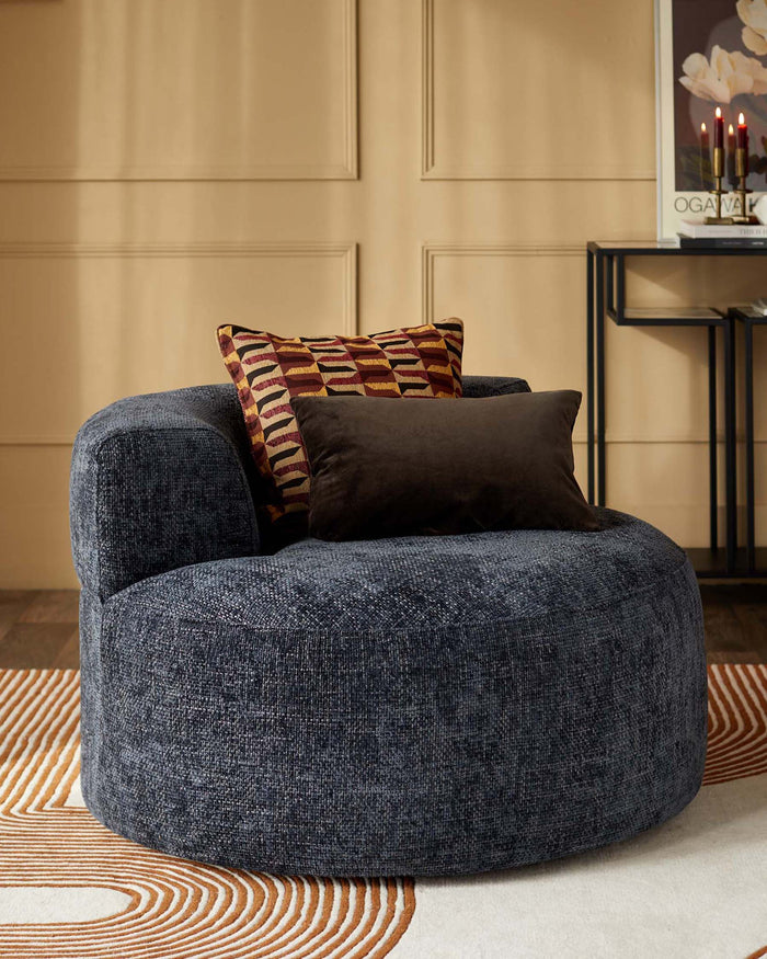 A stylish, round, blue armchair with patterned cushions, perfect for modern living rooms and a comfortable seat.