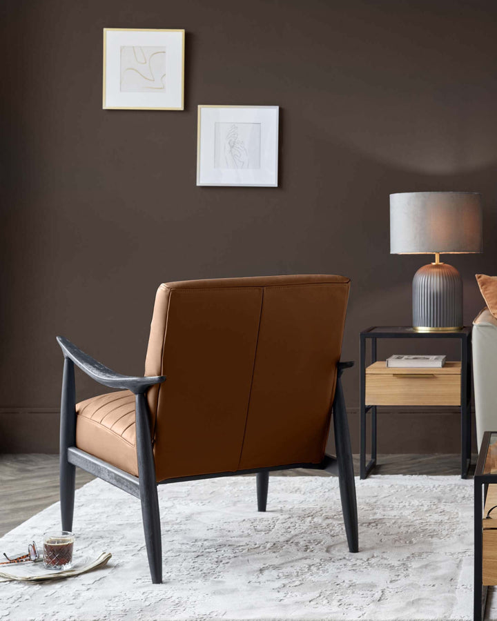Greyson tan leather accent chair with charcoal wood frame, shown from back angle in styled room setting.