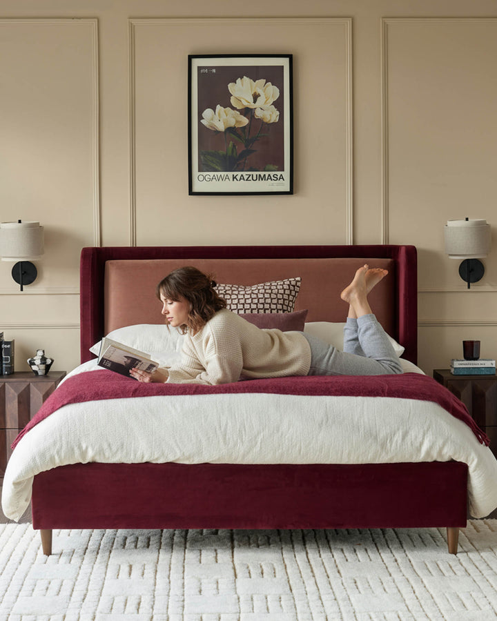 Grove King Ottoman Bed in rose velvet with plum upholstery, styled in a bedroom setting with matching bedding and décor.