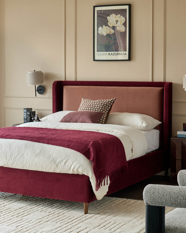 Grove King Ottoman Bed in rose and plum velvet, featuring an upholstered headboard and footboard with wooden legs.