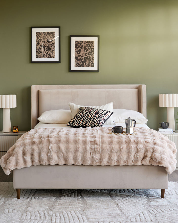 Grove King Ottoman Bed in champagne velvet, displayed in a styled bedroom with neutral bedding and sage green walls.