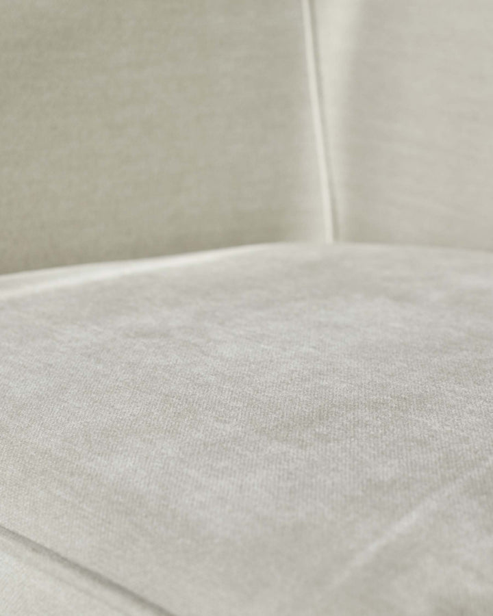 Close-up of a cream, textured sofa seat. Soft, inviting, and modern, perfect for a relaxing living space.