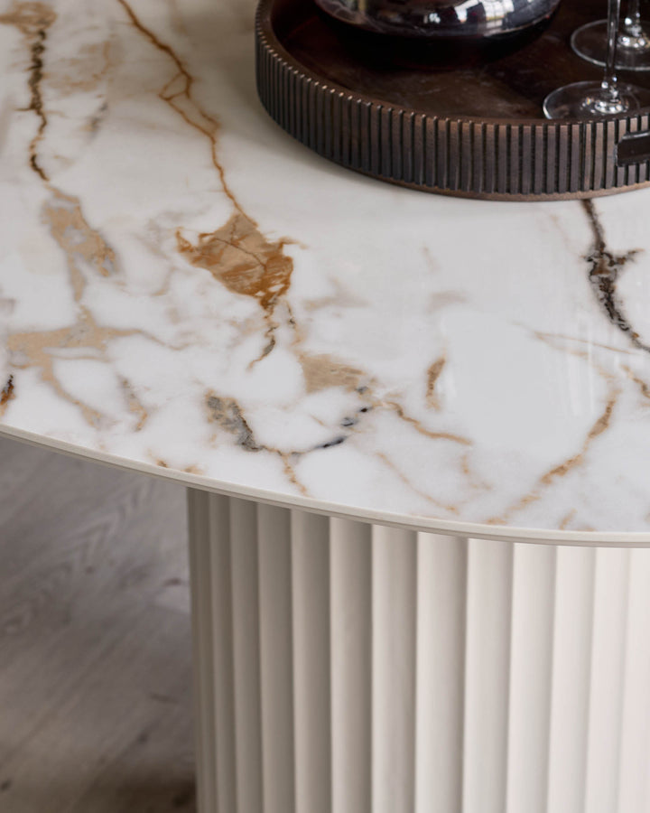 Close-up of a marble-effect table with a fluted base and a ridged tray with glasses on top.