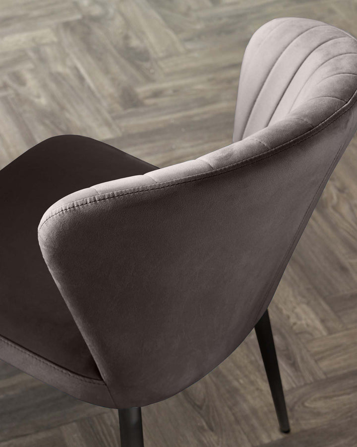 Harper dining chair in mocha velvet with black metal legs, shown from rear angle on herringbone flooring.