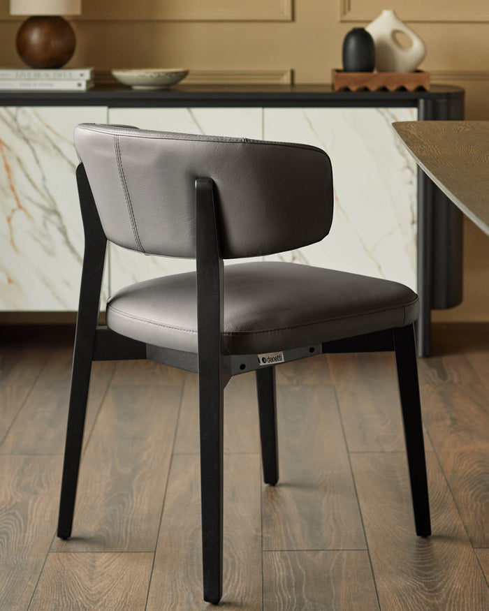 Stylish grey leather dining chair with dark wood frame. Modern design for a chic dining room or kitchen.