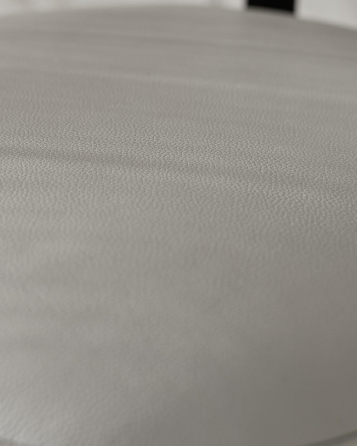 Close-up of a textured grey stool top. Minimalist design ideal for modern interiors.