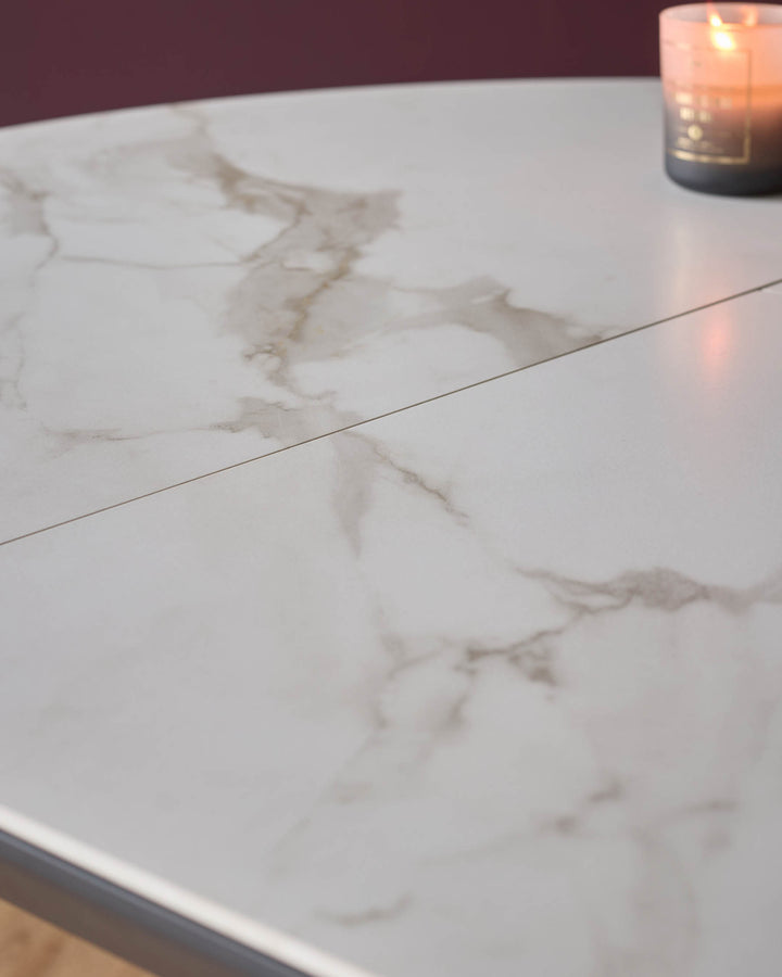 Marble effect extending dining table with a burning candle. Close up of surface. Elegant dining furniture.