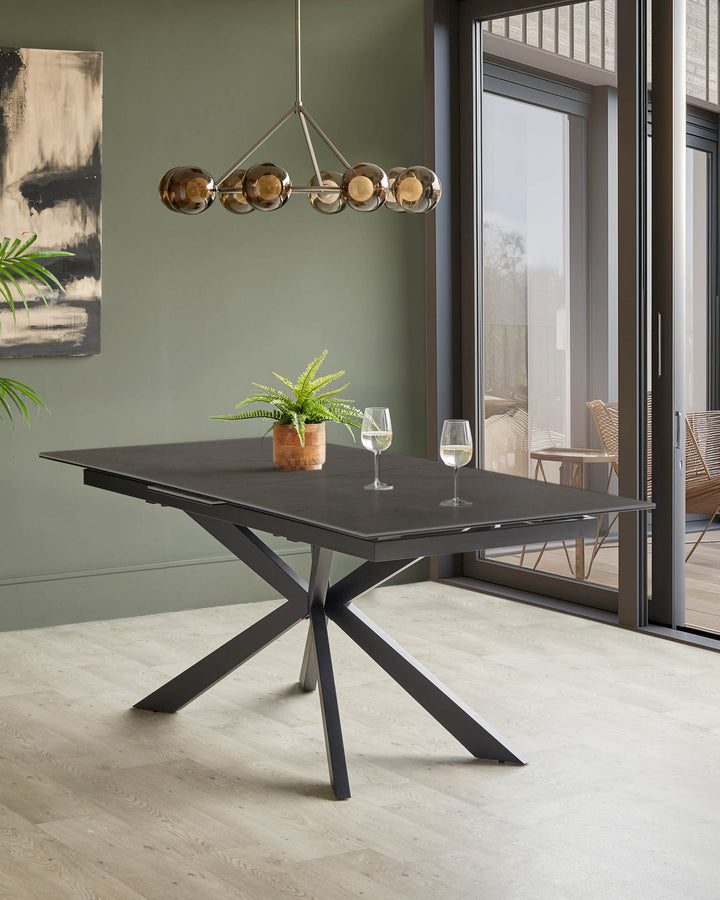 A stylish dining table with a black tabletop and unique leg design, complemented by a modern light fixture.