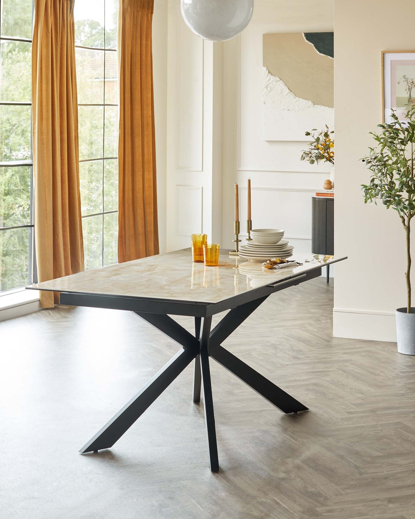 Elegant modern dining table with a marble tabletop and a geometric black metal base.