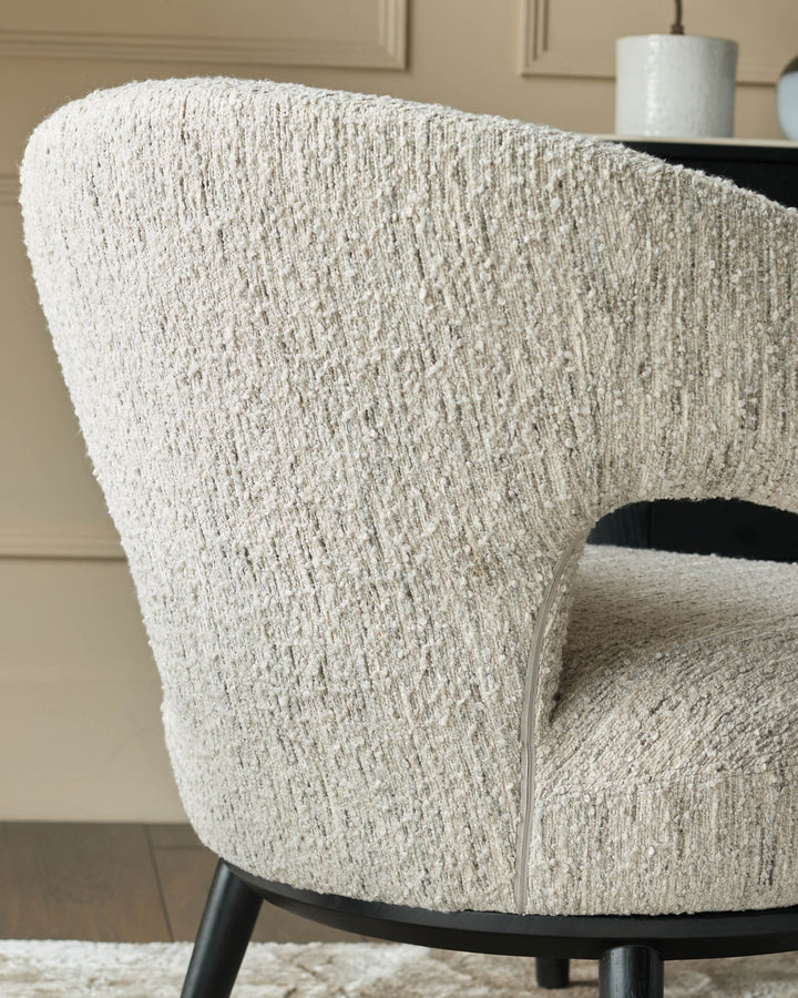 Close-up of a stylish, textured armchair with dark wooden legs, showcasing its unique design and comfort.