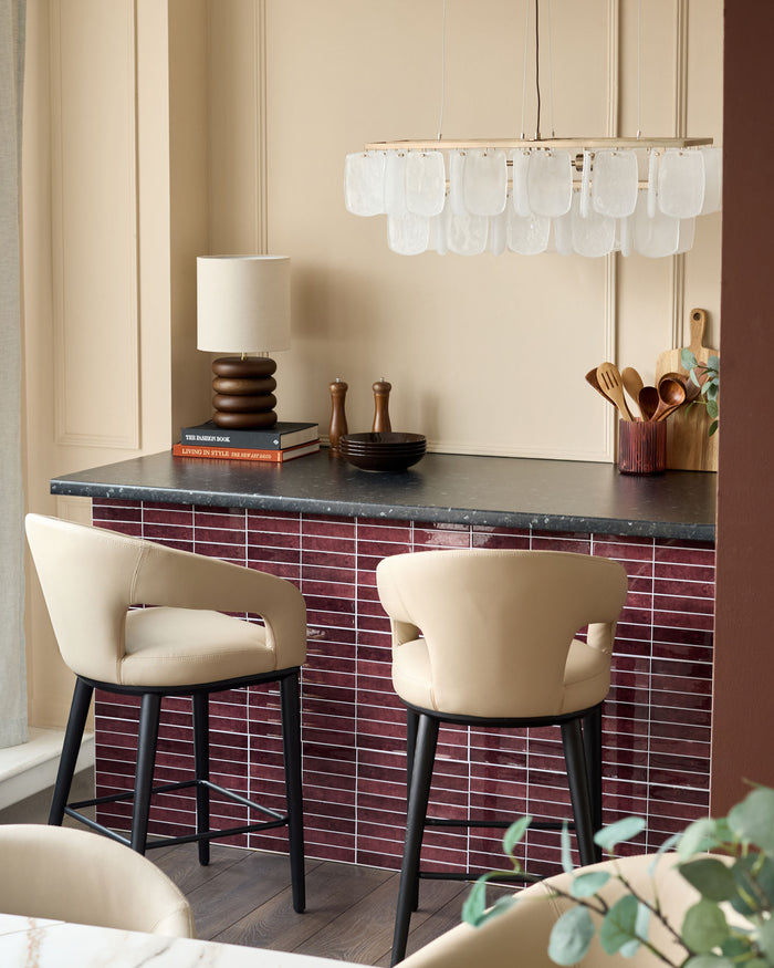 Stylish kitchen island with modern stools, elegant lamp, and unique chandelier, creating a chic and inviting atmosphere.