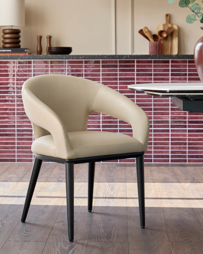 A stylish dining chair with a curved back, upholstered in a neutral fabric, complemented by sleek black legs.