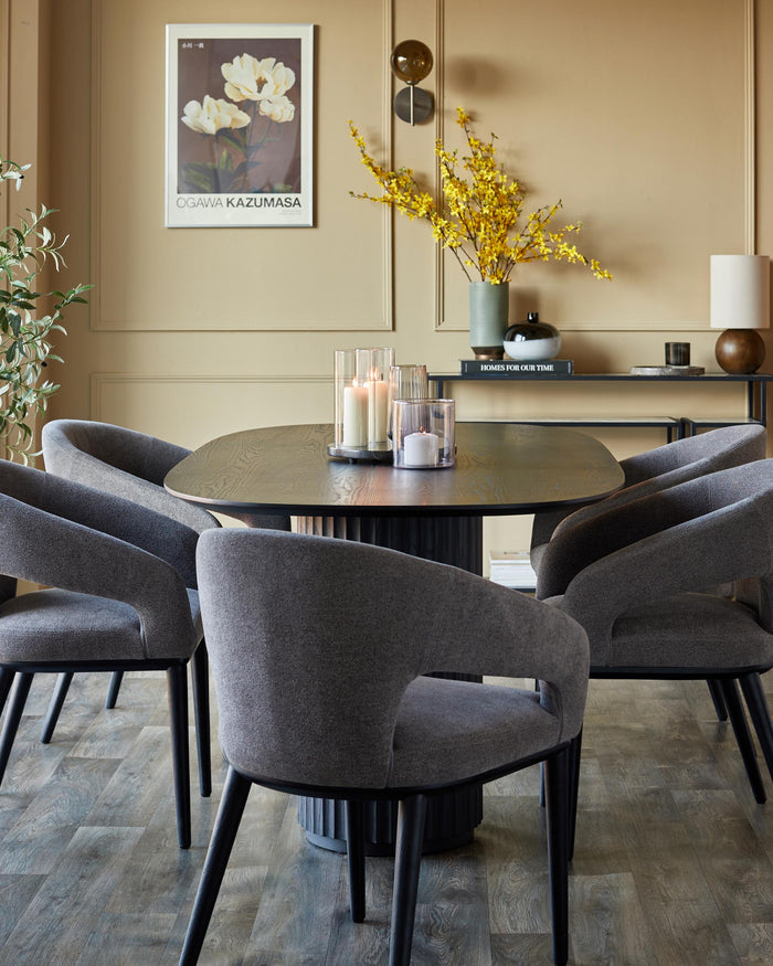 A stylish dining set with a round wooden table surrounded by upholstered chairs, creating an elegant dining space.