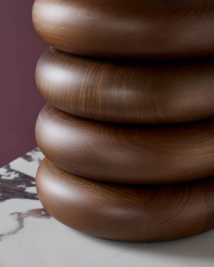 Dark wood stacked ring base with natural finish, close-up side view showing wood grain texture.