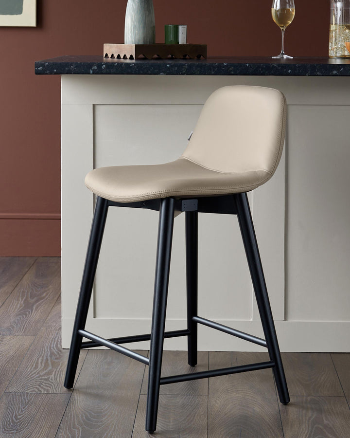 A stylish cream bar stool with black legs, adding a touch of modern elegance to any kitchen or bar area.