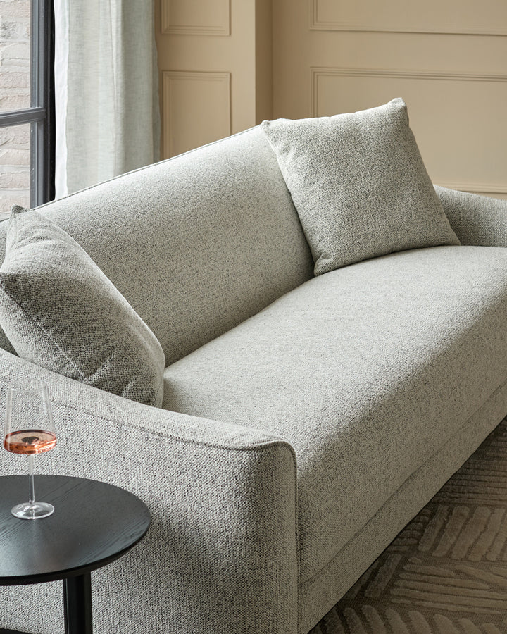Julep Blackwood 3-seater sofa in grey fabric, angled view showing curved arms and back cushions in a neutral interior setting.