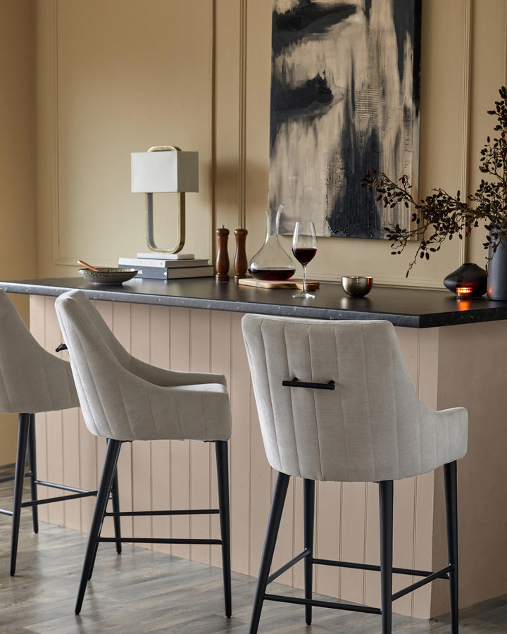 Stylish bar stools with black legs sit at a counter, creating an inviting space for drinks and conversation.