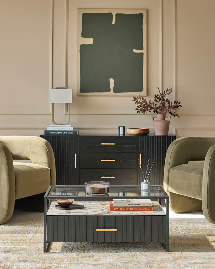 A stylish living room featuring olive velvet chairs, a ribbed sideboard, and a marble-topped coffee table. Modern and elegant.