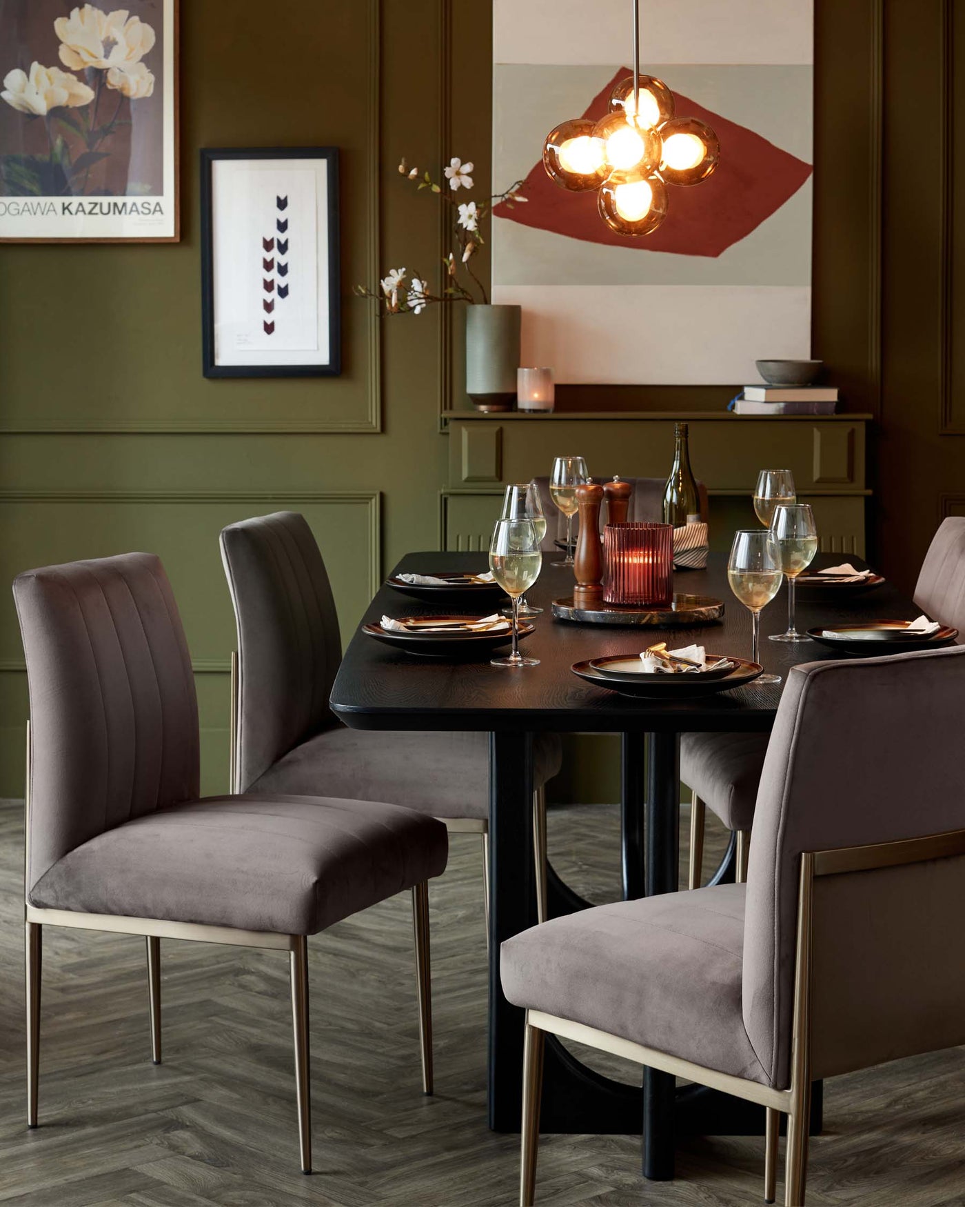 Elegant dining room setup featuring a contemporary black rectangular table with a smooth finish and four plush, upholstered taupe dining chairs with vertical channel tufting and slender metal legs.