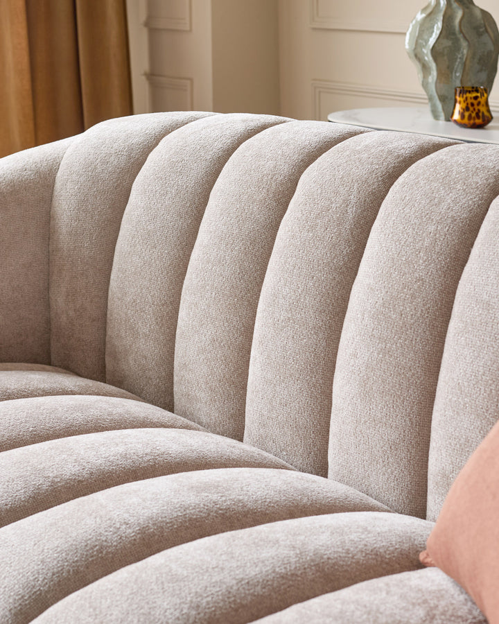 Kendra 3-seater sofa in natural fabric, close-up of curved channel-tufted backrest and seat cushions.