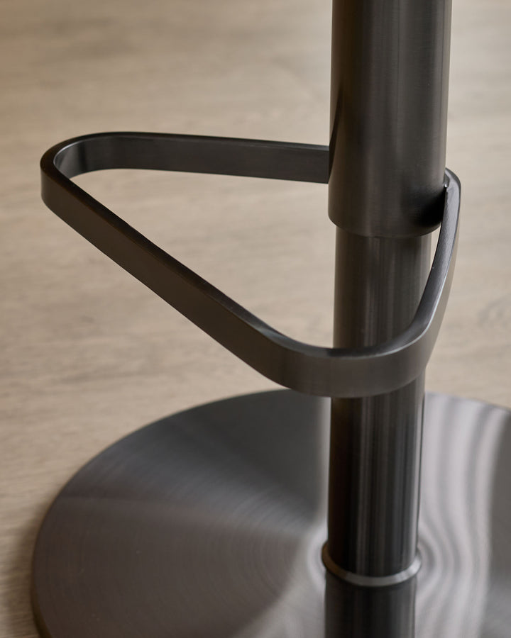 Black gas lift bar stool with grey fabric seat, showing curved backrest and cylindrical metal base detail.