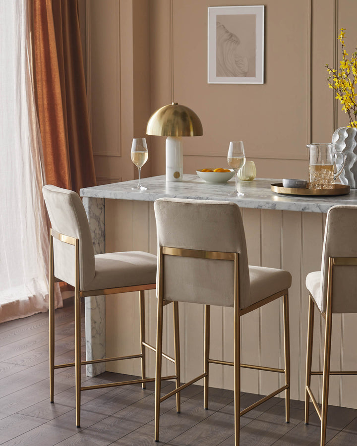 Stylish bar stools with gold frames and plush seats, perfect for a modern kitchen or dining space.