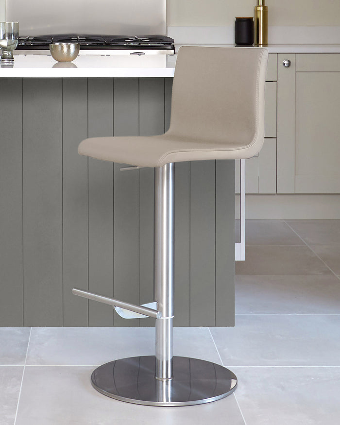 A modern, adjustable height, light-grey bar stool, with a metallic silver stand, in a contemporary kitchen.