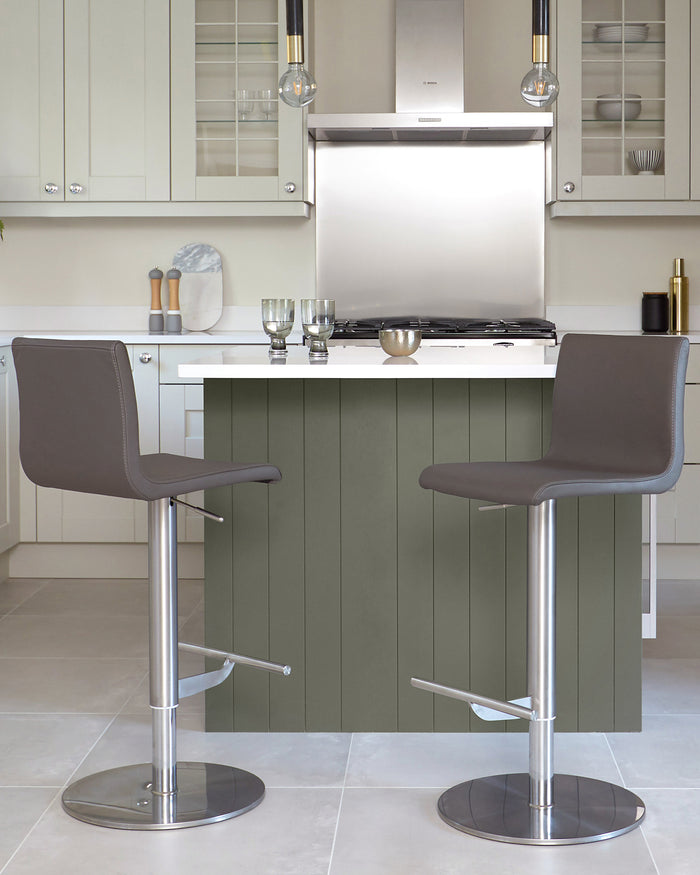 Two grey bar stools with stainless steel bases in a modern kitchen. Stylish seating for your breakfast bar.