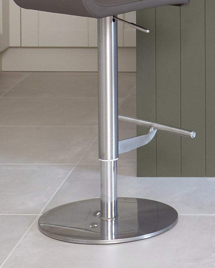 A modern, metallic bar stool with a padded seat and a circular base, perfect for any kitchen island.